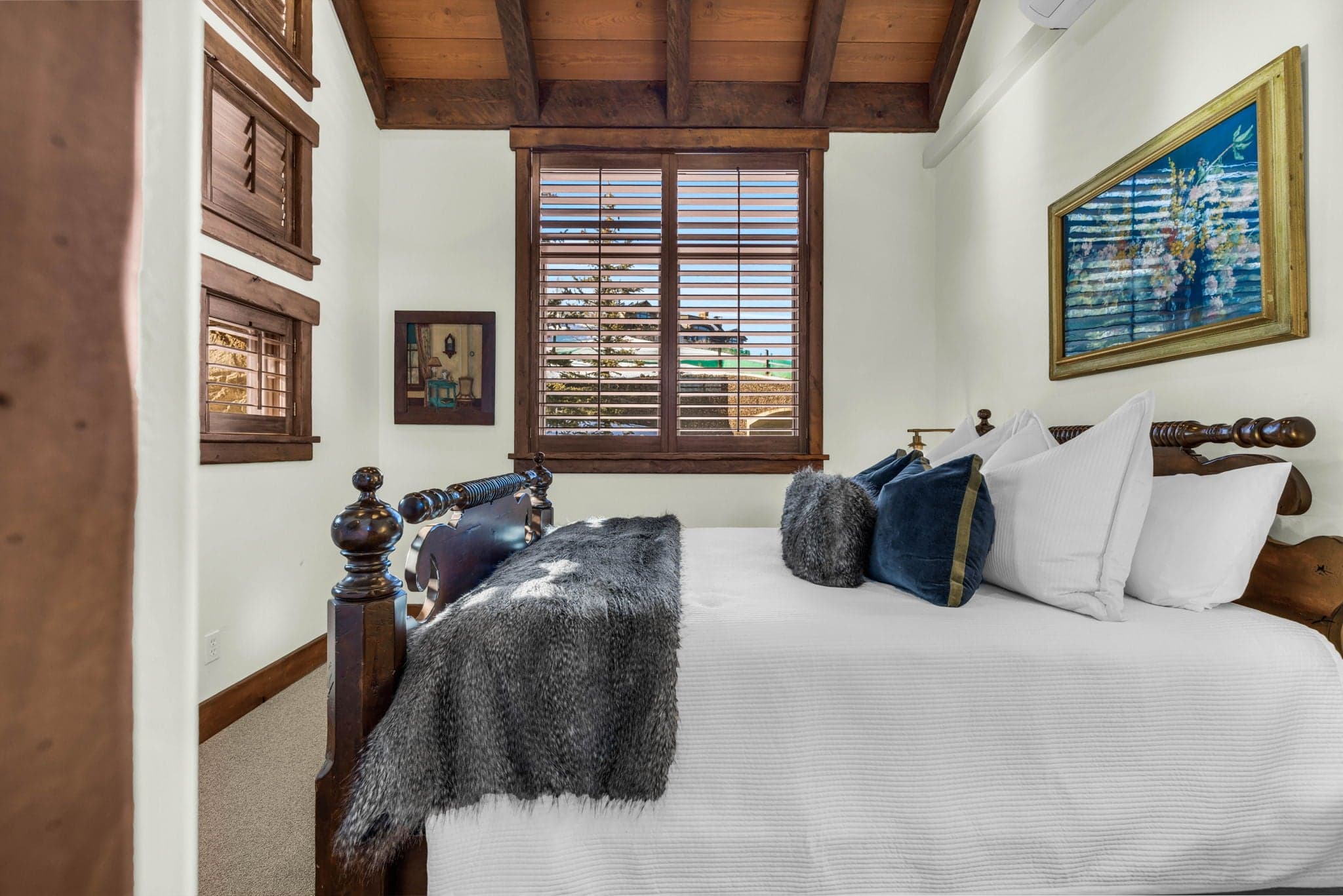 Guest bedroom with twin beds, plush throws, and wooden furniture.