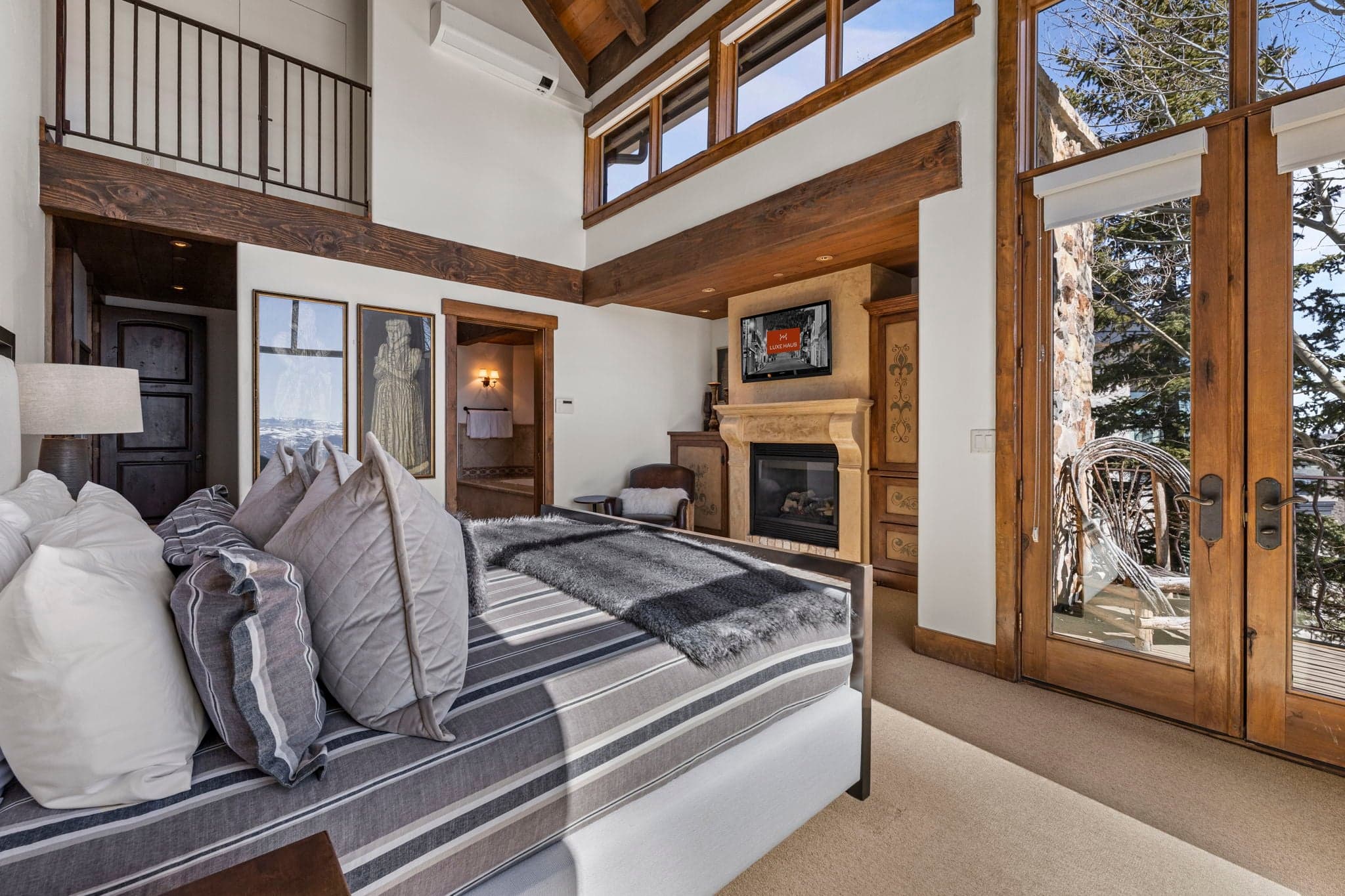 Primary suite with fireplace, tall ceilings, and private balcony access.