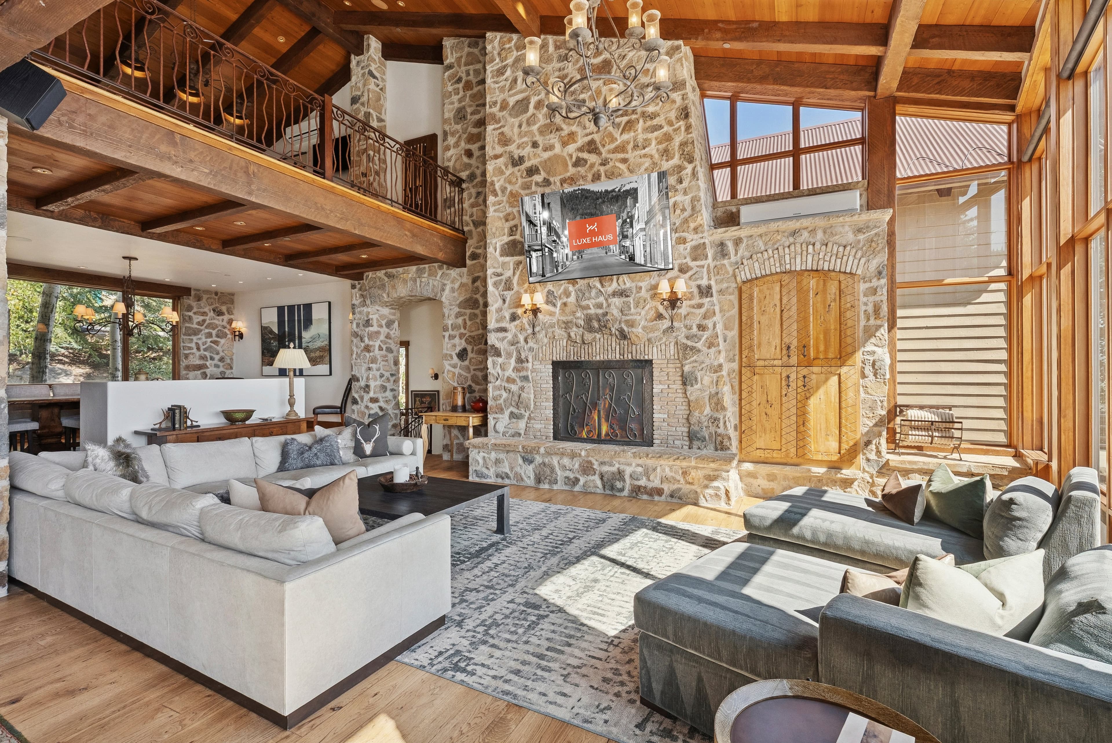 Spacious living room with stone fireplace, vaulted ceilings, and cozy seating.
