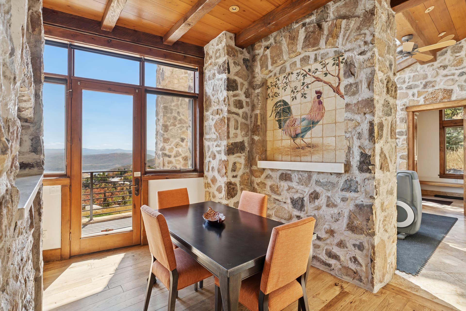 Breakfast nook with stone walls, round table, and mountain view windows.