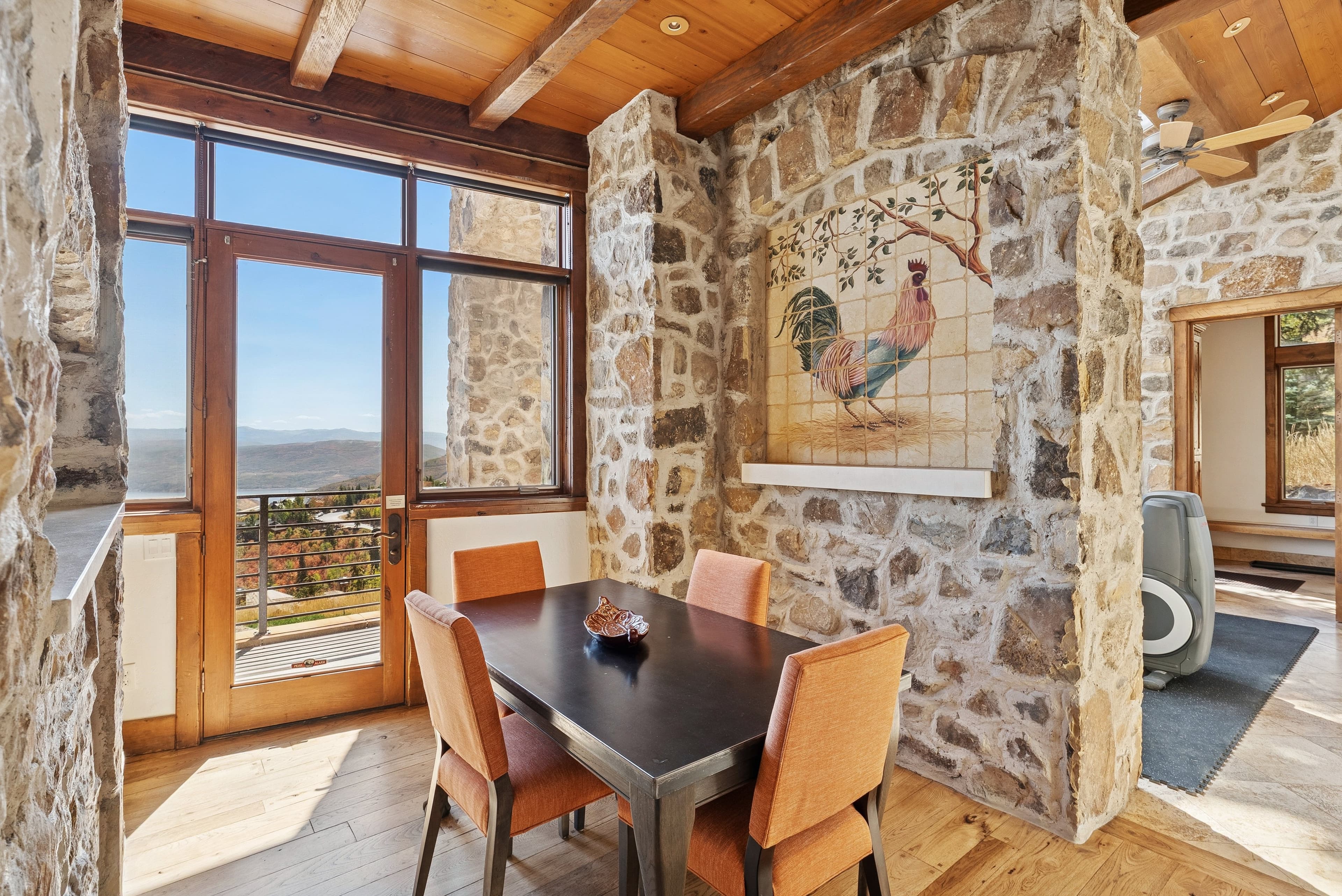 Breakfast nook with stone walls, round table, and mountain view windows.