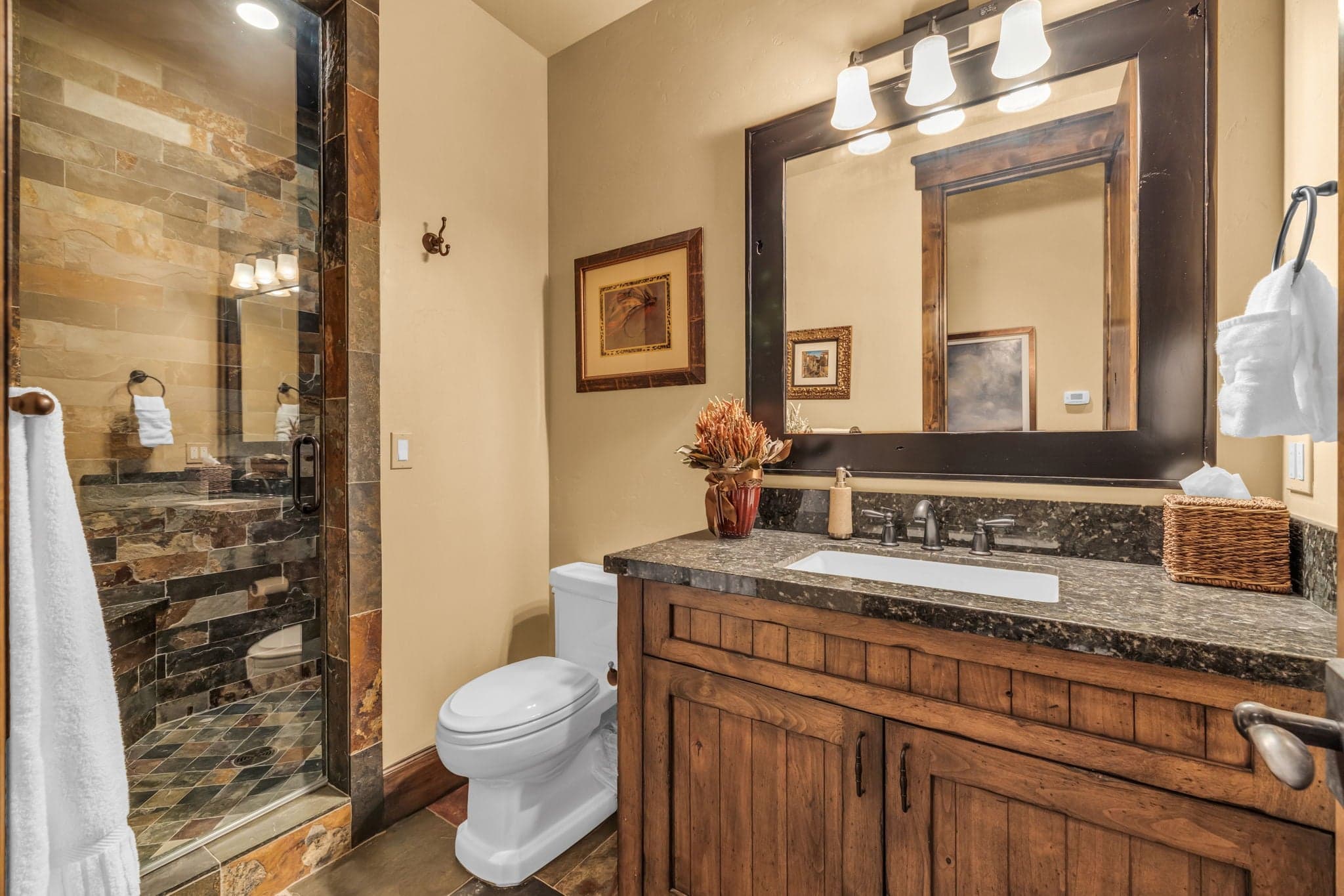 Bathroom with toilet, sink, mirror and shower.