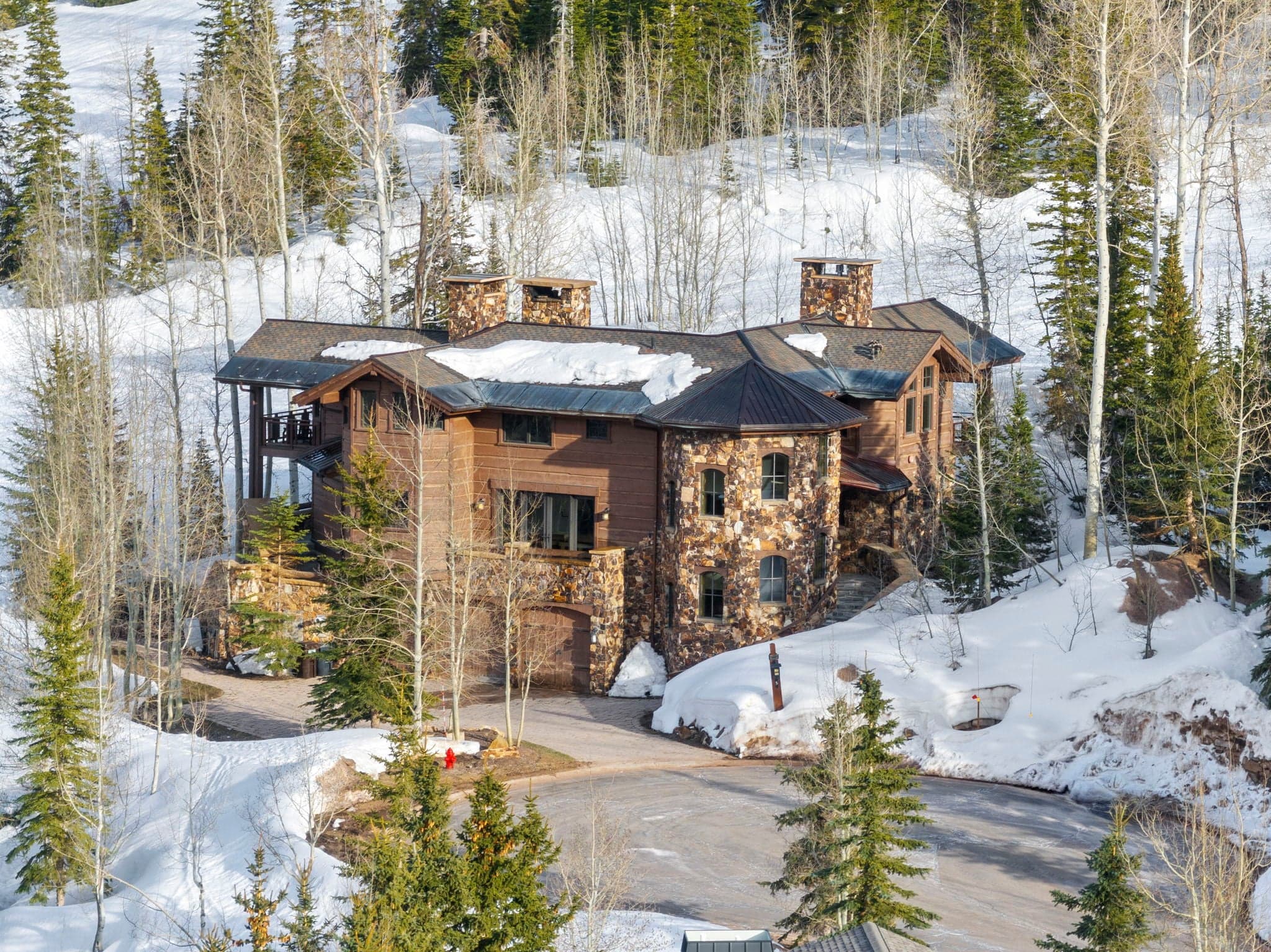 an exterior view of Ski Utah home in Deer Valley with a large ski run right behind the home