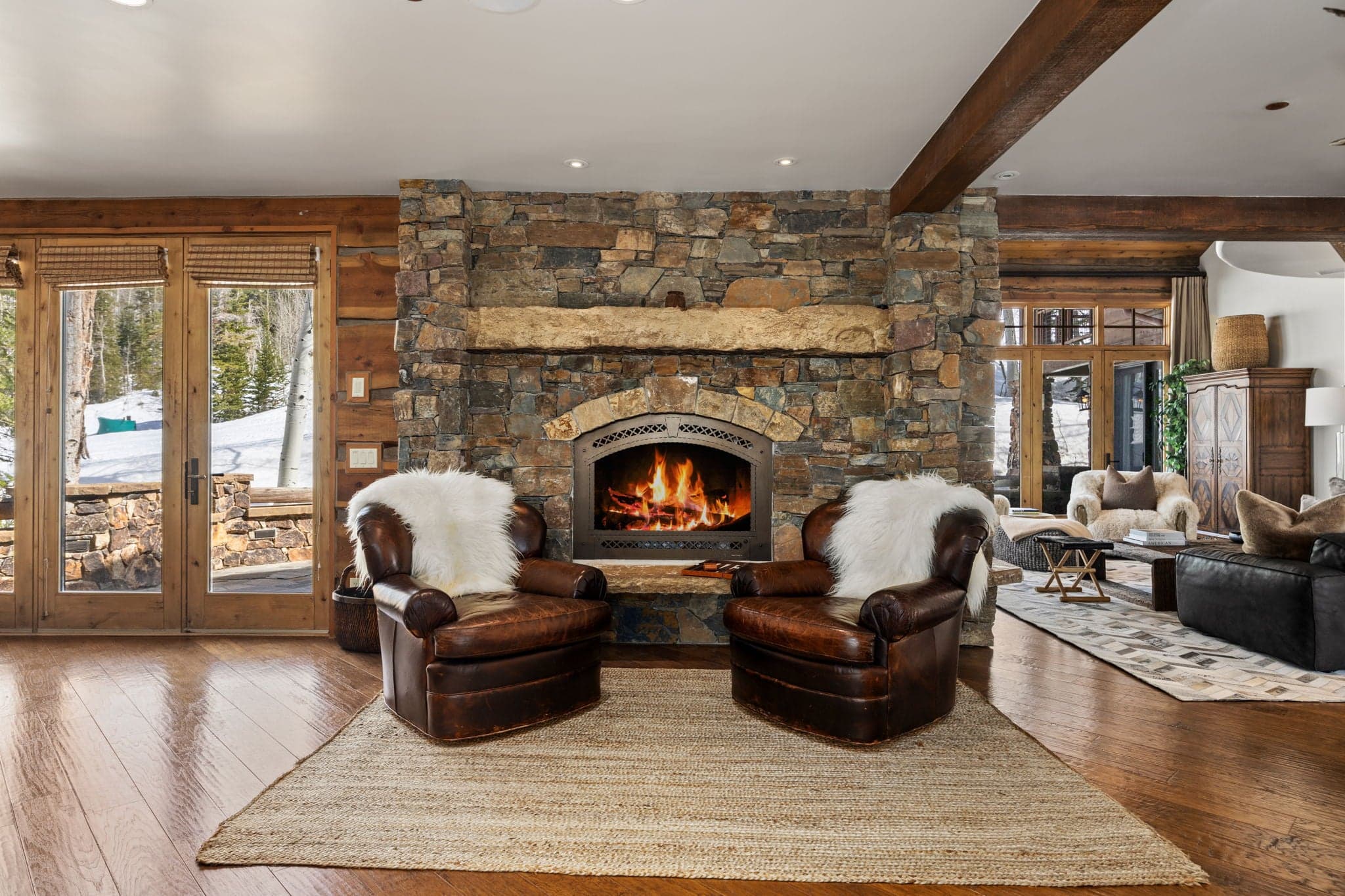 Cozy seating area near the kitchen by a large stone fireplace
